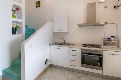 a small kitchen with a stove and a staircase at Villa Ginestra sulla spiaggia di Stromboli in Stromboli