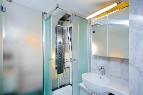 ローマにあるCoronariのバスルーム(洗面台、ガラス張りのシャワー付)