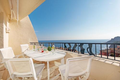un balcon avec une table et des chaises et l'océan dans l'établissement Sea View Duplex YourHostHelper, à Théoule-sur-Mer