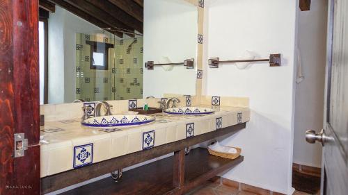 un bagno con due lavandini e un grande specchio di Hotel Hacienda San Martin a Toluca