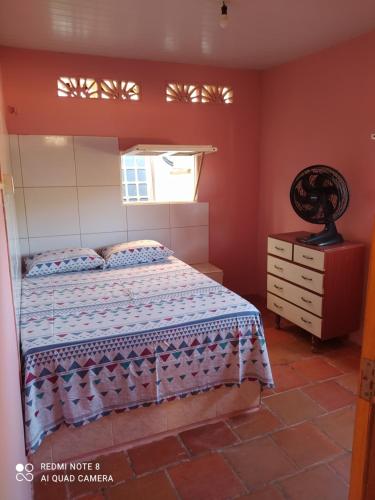 a bedroom with a bed and a window and a dresser at Suítes D'Belinha in Canoa Quebrada