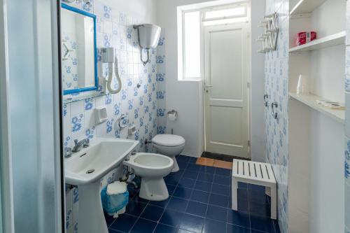 a blue and white bathroom with a toilet and a sink at Villa Mareblu Luxury Holiday Apartment direttamente sul mare in Stromboli