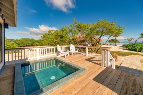 a deck with a swimming pool on top of a house at Barefoot Cay Resort in Roatán