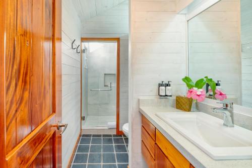 a bathroom with a sink and a shower at Barefoot Cay Resort in Roatán
