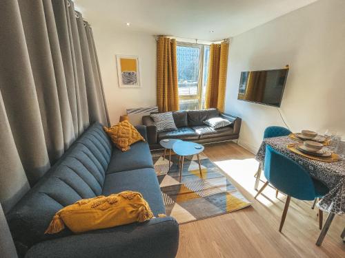 a living room with a blue couch and a table at Modern, stylish Apt 1 min from New St Station in Birmingham