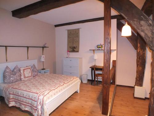 a bedroom with a bed and a desk in it at Taubenhof - Gut Cadenberge in Cadenberge