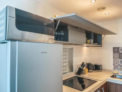 a kitchen with a refrigerator and a stove at Modern, stylish Apt 1 min from New St Station in Birmingham