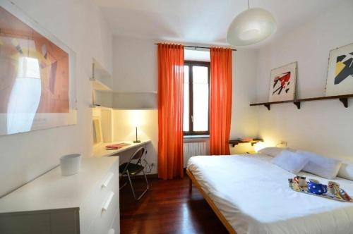 een slaapkamer met een bed, een bureau en een raam bij Como in Milaan