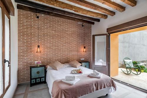 a bedroom with a large bed and a brick wall at Casa Rural de Ancos, Guadamur, Toledo in Guadamur