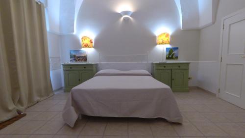 a bedroom with a bed with green cabinets and lights at La Volta in Manduria