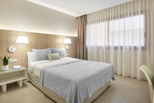 a hotel room with a large bed and a large window at Hotel Omnium in Barcelona