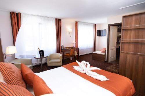 a hotel room with a bed and a bathroom at Hotel Regina & Spa in Berck-sur-Mer