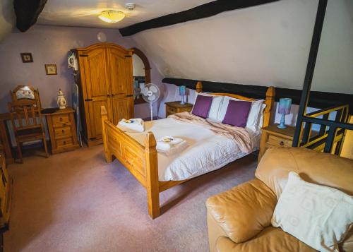 1 dormitorio con 1 cama y 1 sofá en The Mug House Inn, en Bewdley