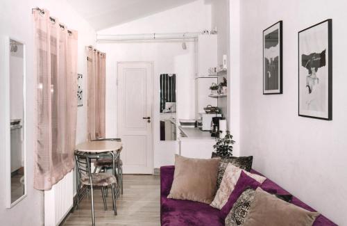 ein Wohnzimmer mit einem lila Sofa und einem Tisch in der Unterkunft Alandala by The Center in Cluj-Napoca