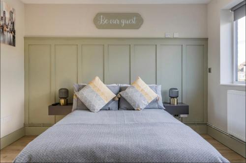 a bedroom with a bed with pillows and a sign on the wall at Seaview 1 bed open condo - free parking in Brighton & Hove