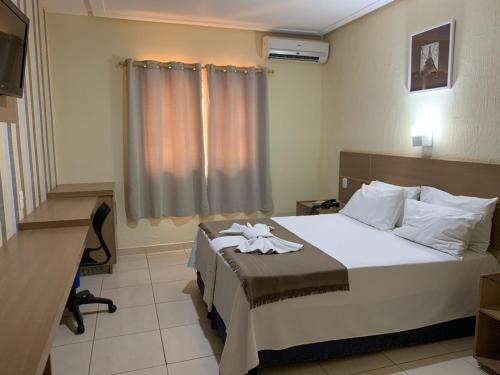 una habitación de hotel con una cama y un escritorio en Fiesta Bahiana Club Hotel, en Irecê