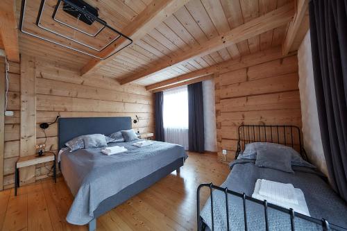 a bedroom with two beds in a wooden cabin at Willa Pod Ściętą Lipą in Ząb