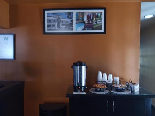 a coffee maker on a table in a room with cupcakes at Hotel Hacienda Del Rio in Tijuana