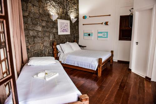 מיטה או מיטות בחדר ב-Pousada Guarubela Villa Vittoria