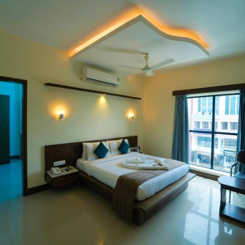 a bedroom with a large bed and a large window at Vari Park - Comfort Stay in Dindigul