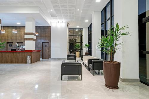 a lobby with a potted plant in the middle at Slim Guarapuava in Guarapuava