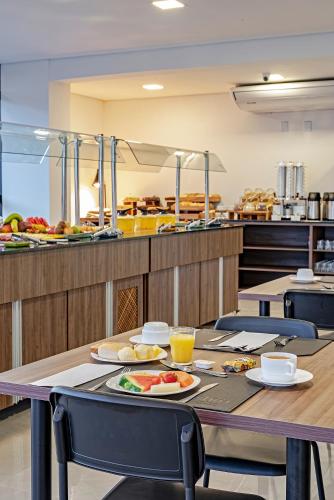 グアラプアバにあるSlim Guarapuavaの食べ物の皿が置かれたテーブル