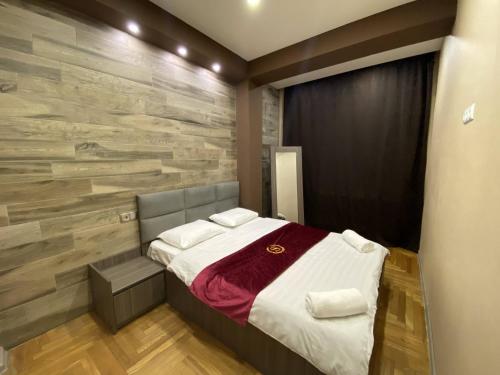 um quarto com uma cama e uma parede de pedra em Superior Apartment on Kostava em Tbilisi