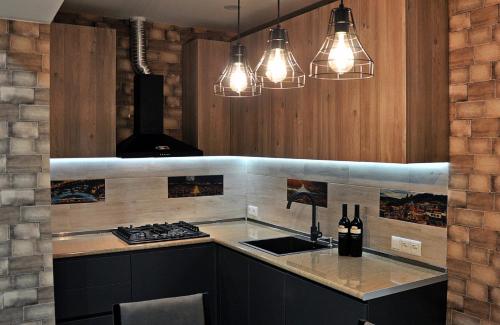 uma cozinha com um fogão e um balcão com luzes em Superior Apartment on Kostava em Tbilisi