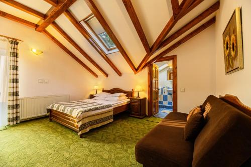a bedroom with a bed and a couch at Regina in Predeal