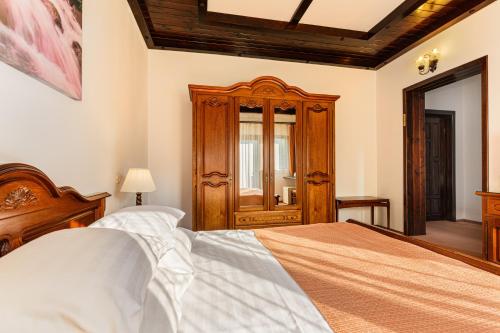 a bedroom with a large bed and a wooden cabinet at Regina in Predeal