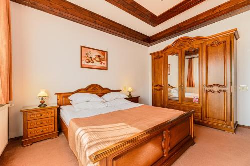 a bedroom with a wooden bed and a wooden dresser at Regina in Predeal