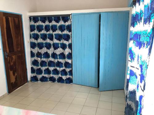 a room with blue doors and a tile floor at OCEAN-SI Mansion in Kribi