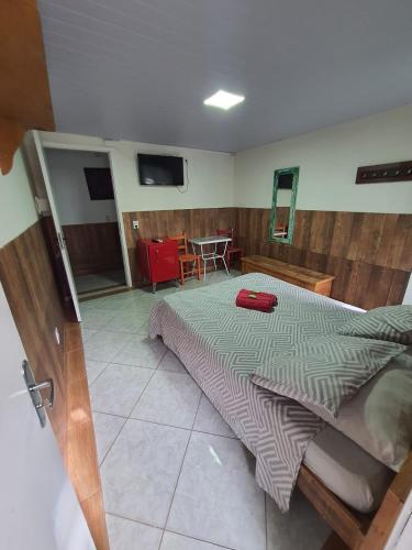 a bedroom with a bed with a red suitcase on it at Pousada Quintal Verde Floripa in Florianópolis