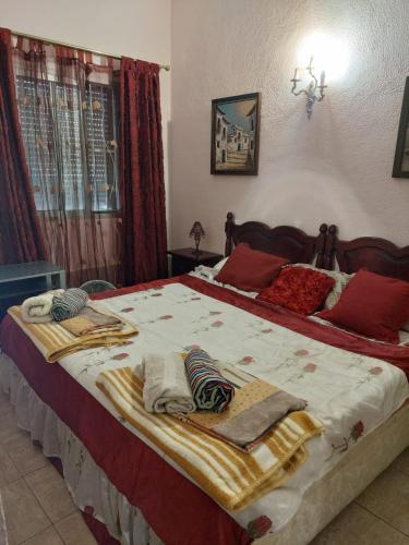 una camera da letto con un grande letto con coperte e cuscini di Bungalow cerca de la playa a Denia