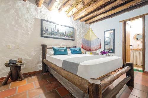 a bedroom with a large white bed with blue pillows at Ayenda Boutique Macaregua Girón in Girón
