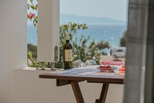 una mesa con botellas de vino y copas en el balcón en Ocean Blue Villa, en Agiassos
