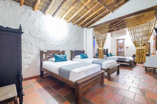 a bedroom with two beds and a fireplace at Ayenda Boutique Macaregua Girón in Girón