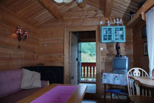 Habitación de madera con mesa y TV en Hesthaug Gard, en Eidsdal