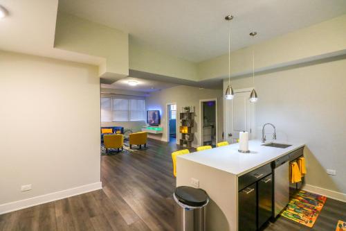 an open kitchen and living room with yellow chairs at Windy Heart Apartment in Chicago