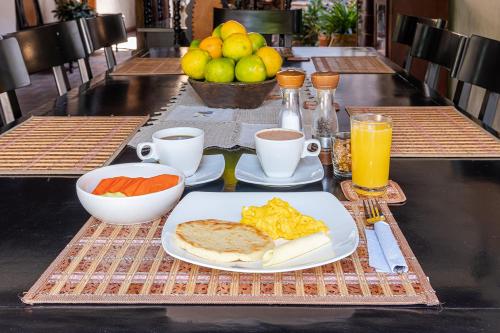 a breakfast table with a plate of food and fruit at Ayenda Boutique Macaregua Girón in Girón