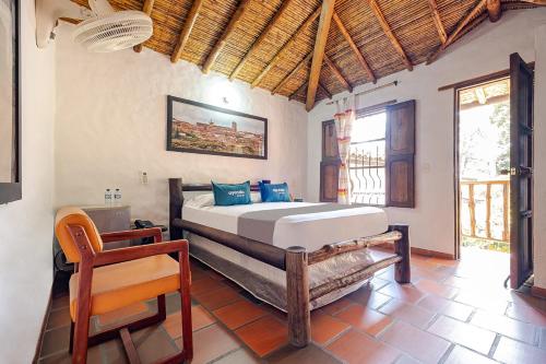 a bedroom with a bed and a chair in it at Ayenda Boutique Macaregua Girón in Girón