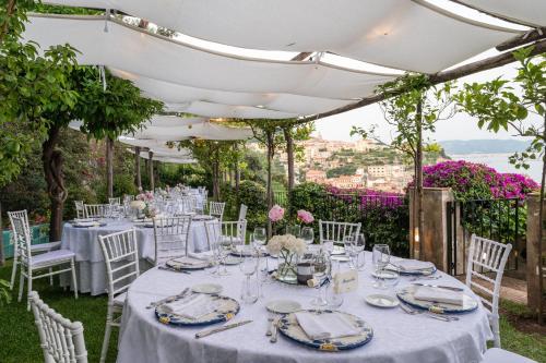 a table set up for a wedding with white tables and chairs at Palazzo Suriano Heritage Hotel in Vietri sul Mare