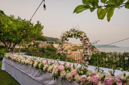 a long table with a bunch of flowers at Palazzo Suriano Heritage Hotel in Vietri sul Mare