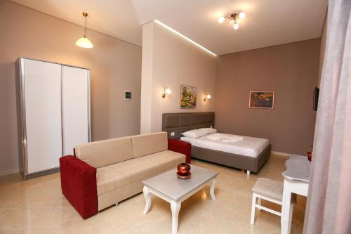 a living room with a couch and a bed at Apartments Serxhio in Sarandë