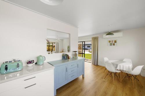 a kitchen with white cabinets and a table and chairs at Greytown Getaway - Greytown Holiday Home in Greytown