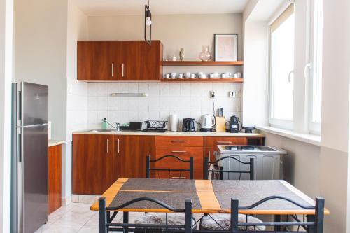 a kitchen with wooden cabinets and a table with chairs at Panorama View Budget Apartment in Veszprém
