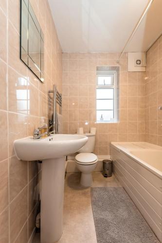 a bathroom with a sink and a toilet and a tub at BEST PRICE! Perfect Gunwharf Accommodation - 5 single beds or Kingsize FREE PARKING in Portsmouth