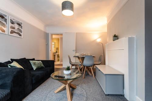 a living room with a couch and a table at BEST PRICE! Perfect Gunwharf Accommodation - 5 single beds or Kingsize FREE PARKING in Portsmouth