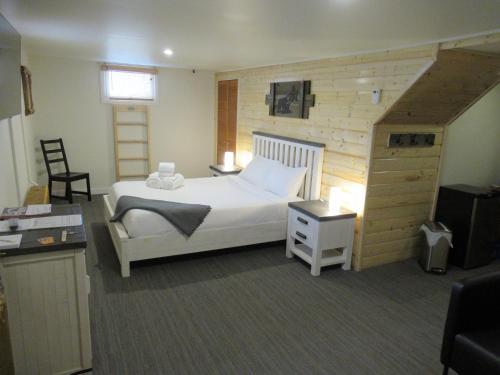 a bedroom with a white bed and a staircase at Bear Rock Inn in Jasper