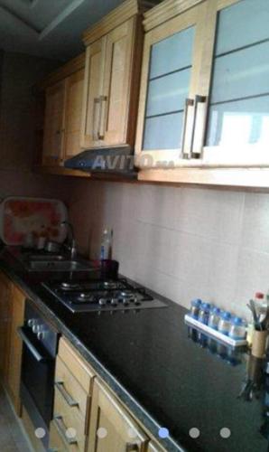 a kitchen with a black counter top and a stove at Appartement à proximité de l'aéroport Mohamed V Casablanca in Nouaseur